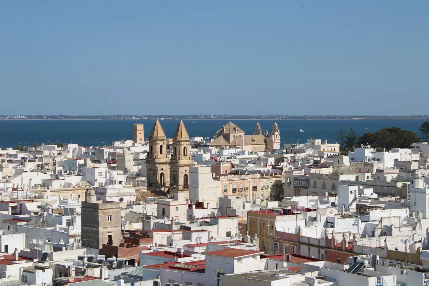 The white rooftops and cathedral towers of Cádiz above the sea